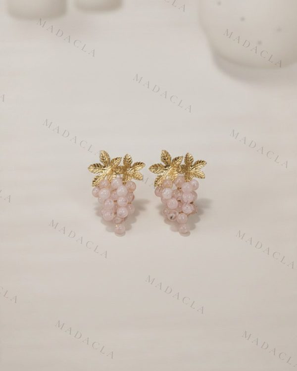 Pendientes con forma de racimo de bolitas rosas claras y hojas doradas metálicas en la parte superior.