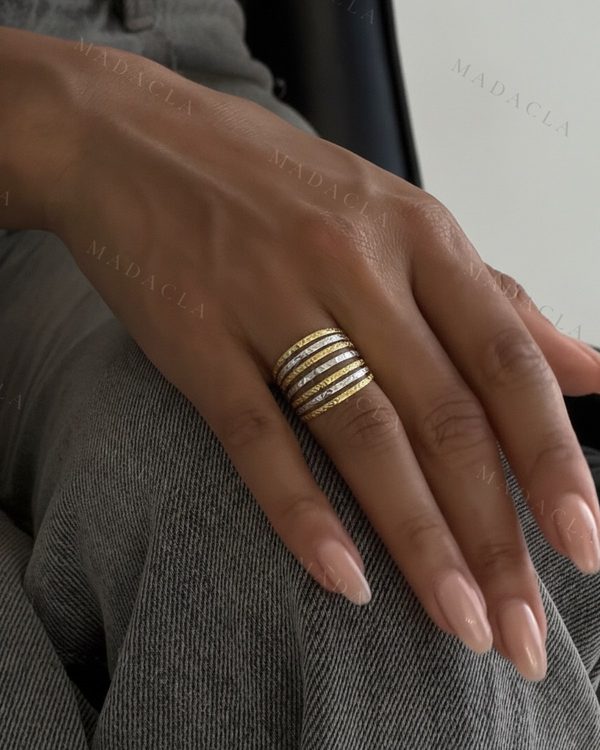 Anillo de seis bandas alternas, en dorado y plateado, con superficie texturizada.
