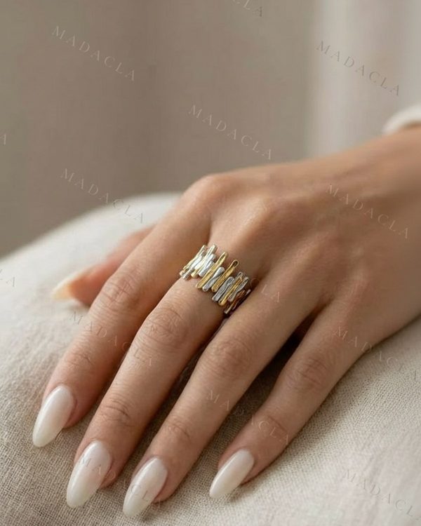Anillo bicolor con diseño de barras irregulares verticales en tono dorado y plateado.