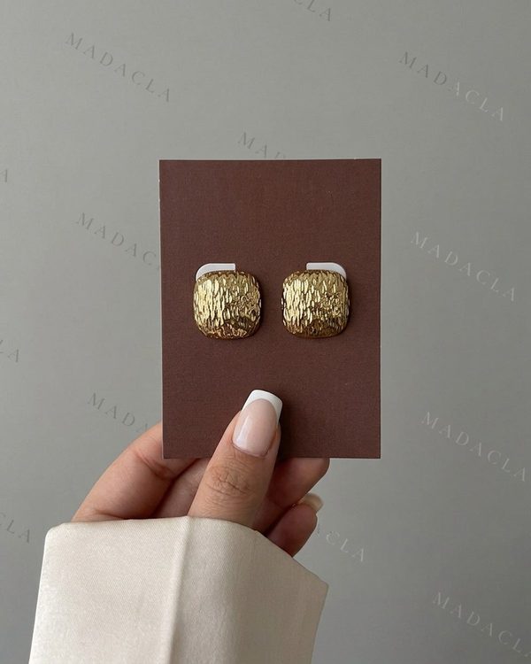 Pendientes cuadrados dorados con esquinas redondeadas y superficie de textura rugosa.