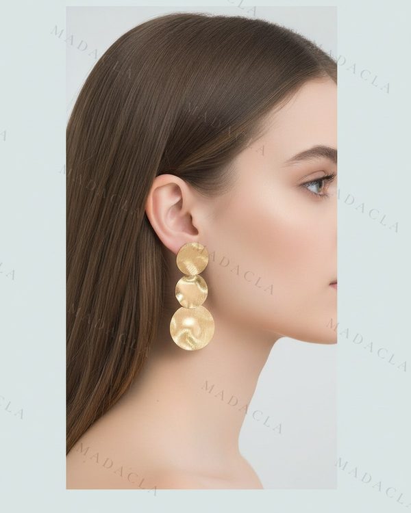 Pendientes largos dorados de tres discos redondos con superficie martillada.
