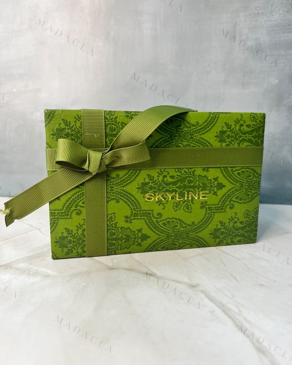 Pack de regalo en caja verde estampada SKYLINE, con reloj dorado de números romanos y dos pulseras doradas con pedrería. Se vende el conjunto completo.