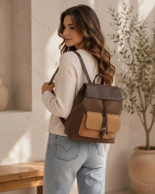 Mochila marrón oscuro con solapa superior de textura diferente y cordón. Delante lleva dos bolsillos con solapa camel y hebilla.