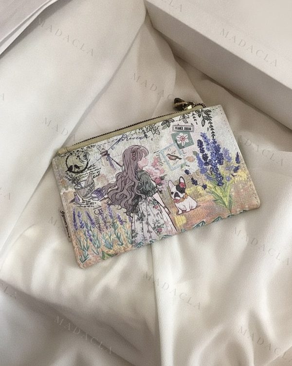 Monedero rectangular con estampado de ilustración campestre: una chica, un perro, lavanda y elementos postales. Cuenta con cierre de cremallera metálica.