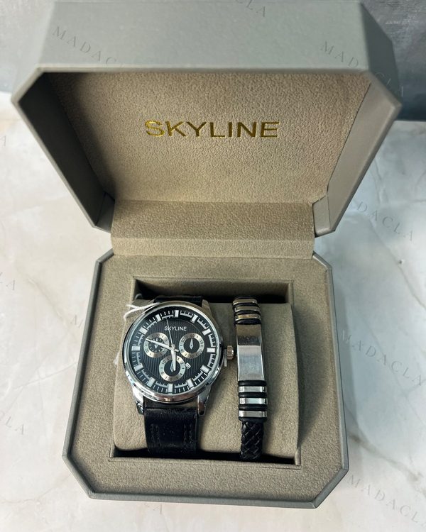 Pack de regalo con reloj de esfera negra, correa negra, grabado SKYLINE, y pulsera de metal con cordón trenzado negro. En caja con SKYLINE.