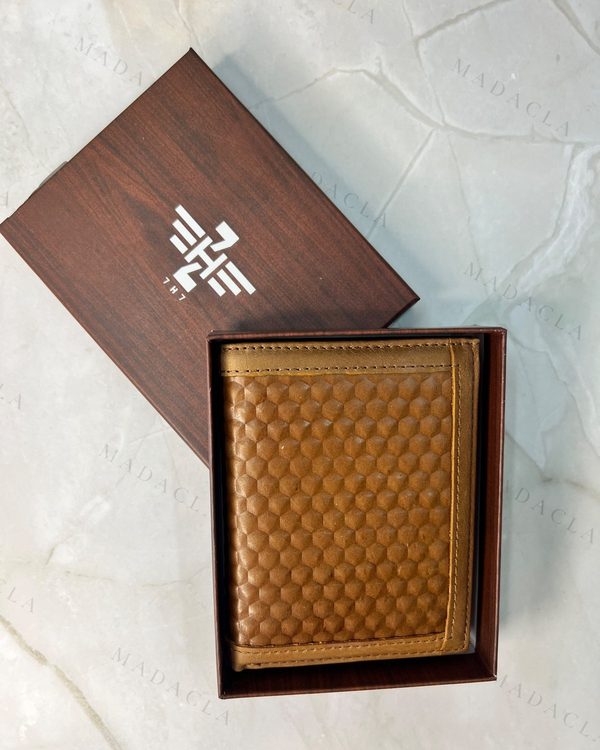Cartera de hombre en tono camel con textura hexagonal en relieve. Plegable, con bordes lisos en marrón más oscuro.