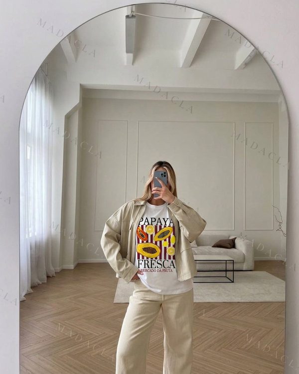 Camiseta blanca de manga corta y cuello redondo, con estampado de papayas y rodajas de limón sobre rayas granates y blancas y las palabras Papaya fresca. Se vende solo la camiseta.