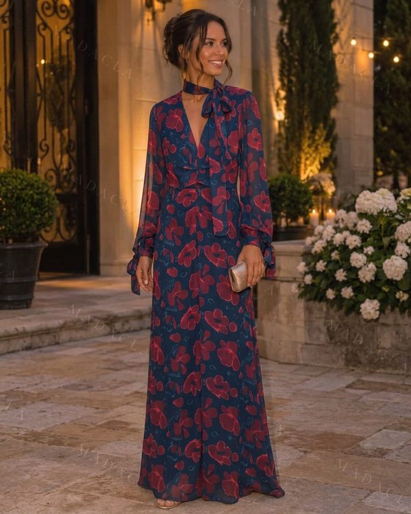 Vestido largo estampado floral azul marino y rojo. Escote en pico con detalle fruncido y lazada al cuello, mangas largas semitransparentes.