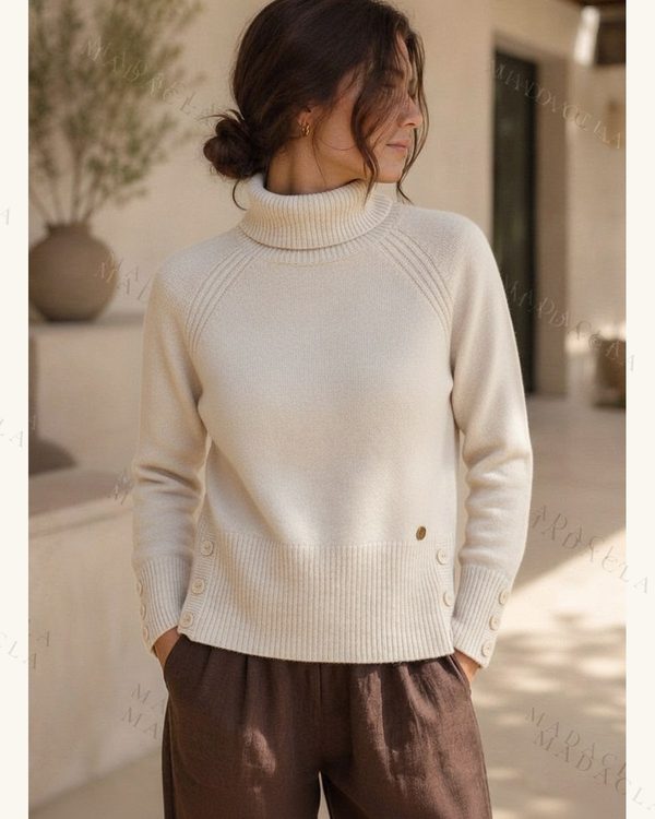 Jersey crudo de punto con cuello vuelto, manga larga y botones en puños y laterales.