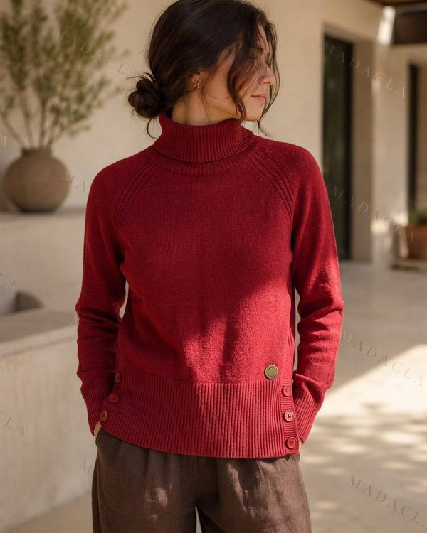 Jersey granate de punto con cuello vuelto, manga larga y botones en puños y laterales.