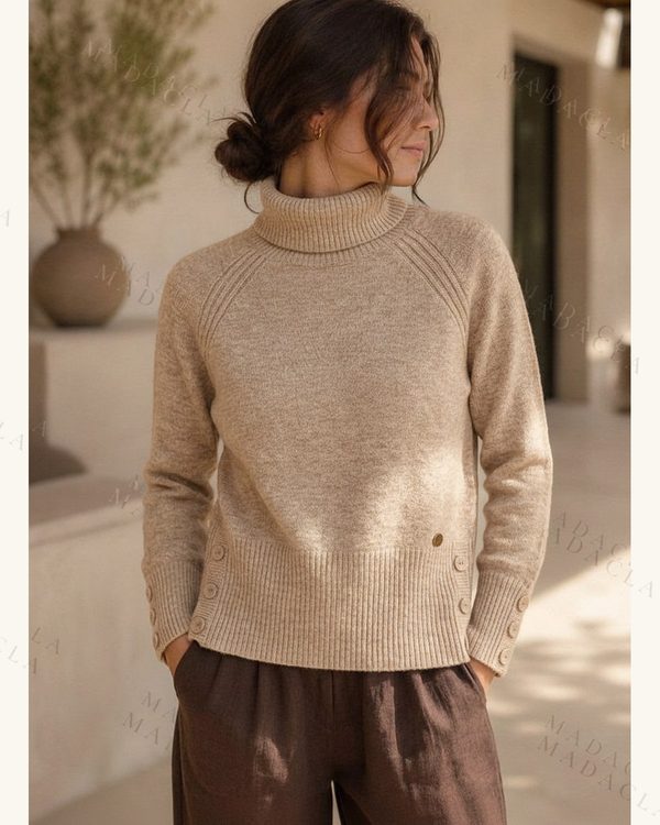 Jersey beige de punto con cuello vuelto, manga larga y botones en puños y laterales.