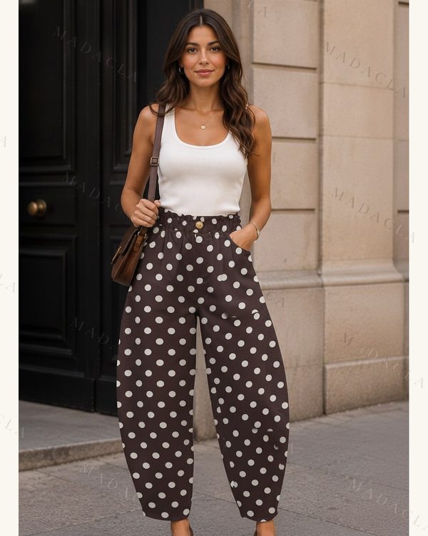Pantalón tobillero de corte ancho abombado, en marrón con lunares blancos. Presenta cintura alta con botones y bolsillos laterales.