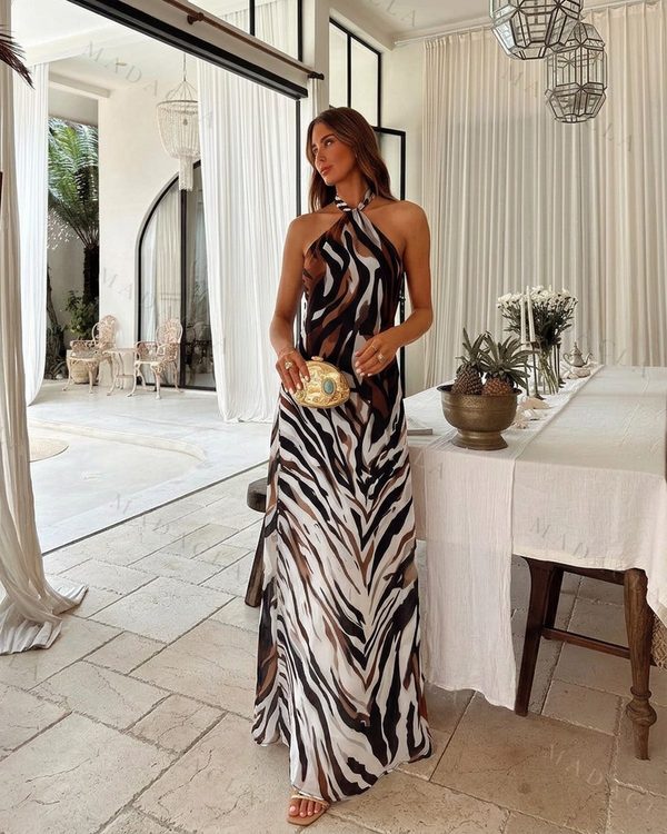 Vestido maxi de tejido fluido con estampado animal print en tonos tierra. Lleva escote halter atado al cuello y una abertura lateral en el bajo.