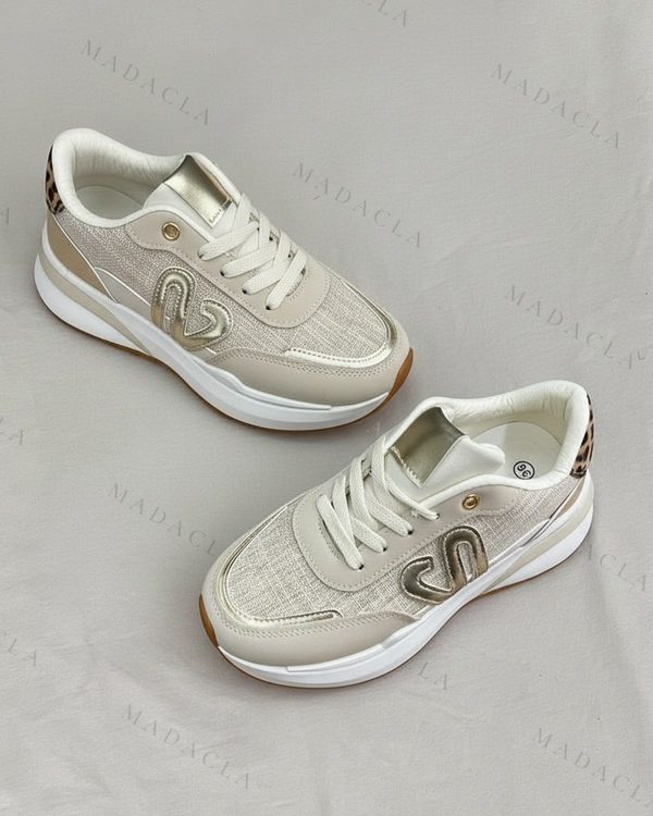 Deportivas beige con paneles de rejilla, cordones y suela blancos, detalles dorados y estampado de leopardo en el talón.