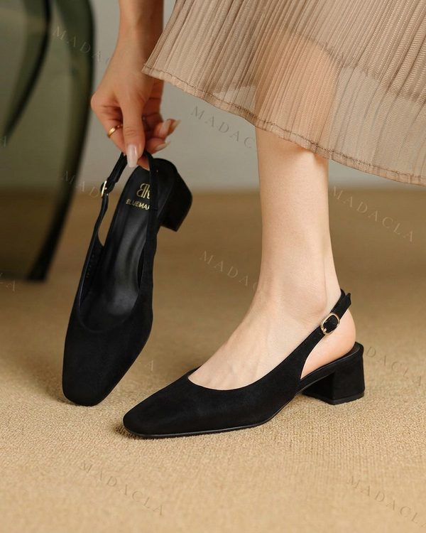Zapatos destalonados negros de antelina con punta cuadrada, tacón bajo de bloque y hebilla dorada. Lleva grabado BLUEMAI.