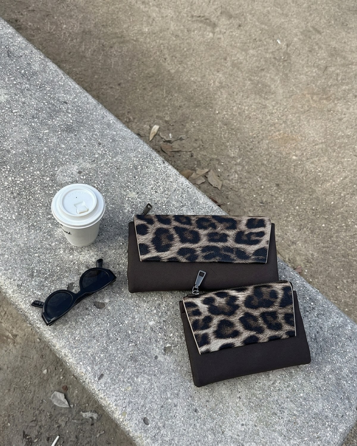 Cartera y monedero a juego, en negro con la solapa de estampado de leopardo y cierre de cremallera. Se venden por separado: puedes llevarte solo uno de los dos.